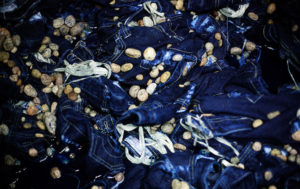 Pumice stones are used to wash jeans in Zhongshan city, China, to give the "stone-wash" look.  This picture is part of a photo and text story on blue jeans production in China by Justin Jin.  China, the "factory of the world", is now also the major producer for blue jeans. To meet production demand, thousands of workers sweat through the night scrubbing, spraying and tearing trousers to create their rugged look.  At dawn, workers bundle the garment off to another factory for packaging and shipping around the world. The workers are among the 200 million migrant labourers criss-crossing China looking for a better life, at the same time building their country into a mighty industrial power.